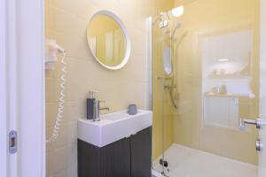 bagno con lavandino, doccia e specchio di My Place Central a Cluj-Napoca