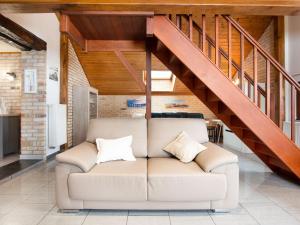 un sofá en una sala de estar con una escalera en Beautiful Holiday Home in Cul des Sarts with Garden, en Cul-des-Sarts