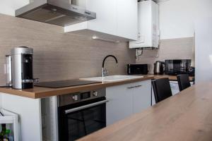 cocina con fregadero y encimera en Renovated T6 house with garden near transport, en Villenave-dʼOrnon