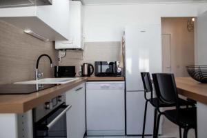 a kitchen with white cabinets and a white dishwasher at Renovated T6 house with garden near transport in Villenave-dʼOrnon