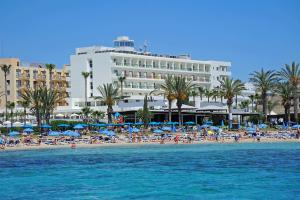 una playa con sillas y sombrillas frente a un hotel en Nelia Beach Hotel & Spa en Ayia Napa