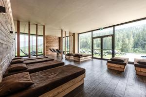 een grote kamer met meerdere bedden en grote ramen bij Gaia Residence Hotel in Mezzana