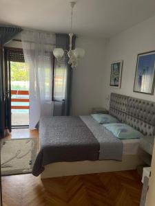 ein Schlafzimmer mit einem großen Bett und einem Fenster in der Unterkunft Makjanic Apartment in Jelsa