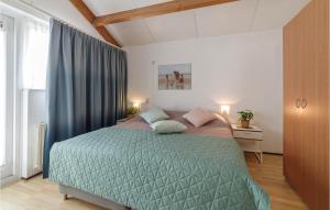 een slaapkamer met een bed met een groen dekbed bij Pet Friendly Home In Wemeldinge With Sauna in Wemeldinge