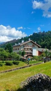 un gran edificio con un campo de hierba delante de él en Ai Grisi, en Cavalese