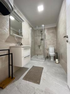 ein Bad mit einer Dusche, einem Waschbecken und einem WC in der Unterkunft D&M APARTMENTS in Rab