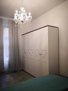 a bedroom with a large white cabinet and a chandelier at Z-1 Kraków Old Town O&P ApartFamily in Kraków +13 photos