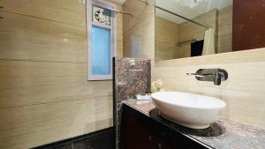 a bathroom with a sink and a mirror at OLIVE Service Apartments DLF Galleria Gurgaon in Gurgaon