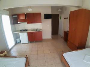 eine kleine Küche mit roten Schränken und ein Bett in einem Zimmer in der Unterkunft Villa Metaxa in Paralia Katerinis