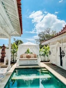 ein Schlafzimmer und einen Pool mit einem Bett und einem Zelt in der Unterkunft Mytongos Private Villa in Nusa Lembongan