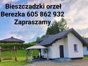 een klein wit huis met een tuinhuisje bij Bieszczadzki Orzeł in Berezka