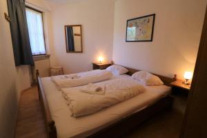1 dormitorio con 2 camas con sábanas blancas y 2 lámparas en Fewo 12 - Residenz Schauinsland, E-Ladestation, Todtnauberg, Feldberg, en Todtnauberg