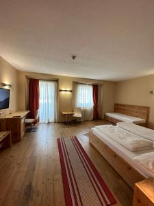 a hotel room with two beds and a desk at Alpenhof in Seefeld in Tirol