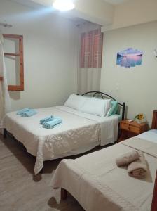 a bedroom with two beds with towels on them at LITHERI-Studios&Apartment in Paleokastritsa
