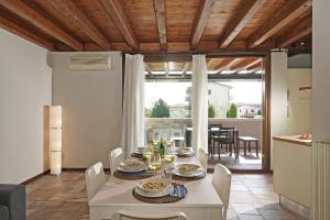 uma cozinha e sala de jantar com uma mesa branca e cadeiras em Garofano P1-9 by Wonderful Italy em Desenzano del Garda