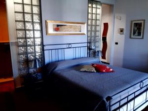 ein Schlafzimmer mit einem blauen Bett und einem roten Kissen darauf in der Unterkunft Dilly Home Holiday-Casa vacanze in Aci Castello