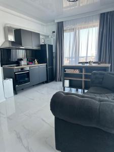 a living room with a couch and a kitchen at Koya Tower by Lake Mamaia in Mamaia