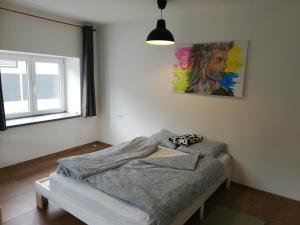 1 dormitorio con 1 cama y una pintura en la pared en LOFT 4 Exklusives Studio Atelier Red Bull Ring Airpower MotoGP en Fohnsdorf