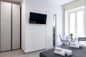 a living room with a bed and a tv on a wall at Partenope Guest House in Naples