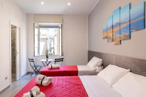una camera con 2 letti e un tappeto rosso di Partenope Guest House a Napoli