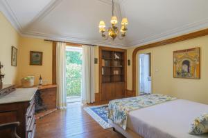 een slaapkamer met een bed, een bureau en een raam bij Outeiro Tuías - Manor House in Marco de Canavezes