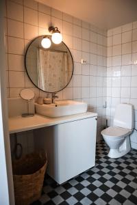 a bathroom with a sink and a mirror and a toilet at Ludvigsdal Semesterboende in Ystad