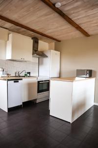 uma cozinha com armários brancos e um forno com placa de fogão em Ludvigsdal Semesterboende em Ystad