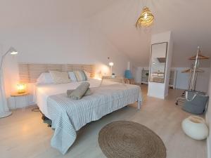 1 dormitorio con 1 cama blanca grande y espejo en Casa Del Mar, piscina privada frente al mar, en Cullera