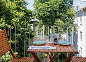 a wooden table with a bottle of wine and plates at Schönbrunn Garden View Apartments in Vienna