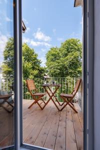 a patio with two chairs and a table on a deck at Schönbrunn Garden View Apartments in Vienna