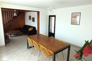 een woonkamer met een houten tafel en stoelen bij Maison tout confort avec jardin in Cayeux-sur-Mer