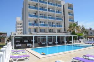 a hotel with a swimming pool in front of a building at Yasmin Hotel in Ayvalık +35 photos