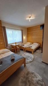 a room with three beds and a table in it at U Bizioma in Murzasichle