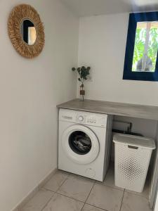 eine Waschmaschine in einem Zimmer mit Spiegel in der Unterkunft Le Pavillon de Nina in Puget