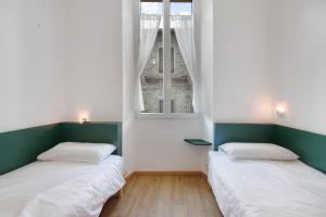 twee bedden in een kamer met een raam bij Workation Castle - Casa Galbiga in Carlazzo
