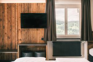 a hotel room with a flat screen tv on the wall at Kristiania Small Dolomites Hotel in Selva di Val Gardena