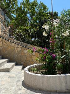 a large stone planter with flowers and stairs at D&M APARTMENTS in Rab