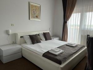 een wit bed in een kamer met een raam bij Rooms Elez in Sesvete
