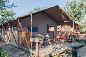 une maison avec un panneau indiquant le café devant elle dans l'établissement Camping Sènia Riu, à Sant Pere Pescador