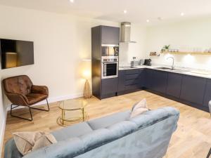 a living room with a couch and a kitchen at The Grange Cottage 2 in Grimsby