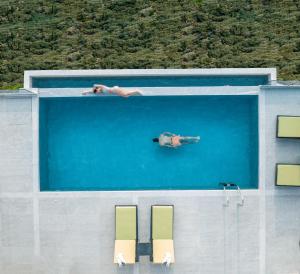 a man is swimming in a swimming pool at Anadeo Villas & Suites in Exanthia