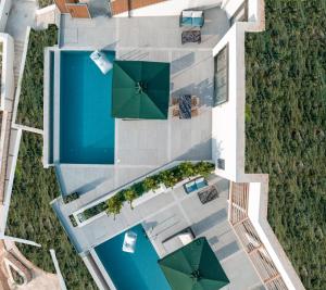 an overhead view of a swimming pool with umbrellas at Anadeo Villas & Suites in Exanthia