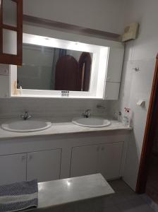 a bathroom with two sinks and a mirror at LITHERI-Studios&Apartment in Paleokastritsa