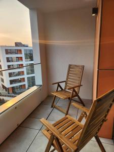 duas cadeiras sentadas na varanda de um apartamento em Prie Vilneles Apartment em Vilnius