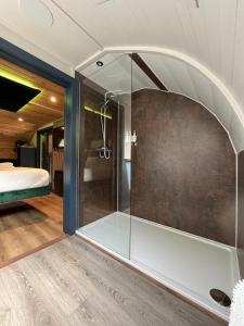 um chuveiro de vidro num quarto com uma cama em Wonderland Retreats em Carnforth