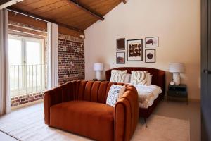 uma sala de estar com um sofá e uma cama em The Chelmsford Hideaway - Spacious 5BDR House with Patio + Garden em Chelmsford