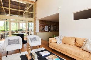 uma sala de estar com um sofá e duas cadeiras em The Chelmsford Hideaway - Spacious 5BDR House with Patio + Garden em Chelmsford
