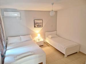 Camera piccola con 2 letti e una lampada di Sala apartment's a Sarandë