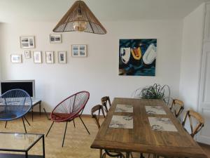 een eetkamer met een houten tafel en stoelen bij Logement Colmar centre avec Parking in Colmar