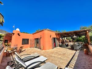 a group of chairs on a patio in front of a house at Tropical Garden Finca in Guía de Isora
